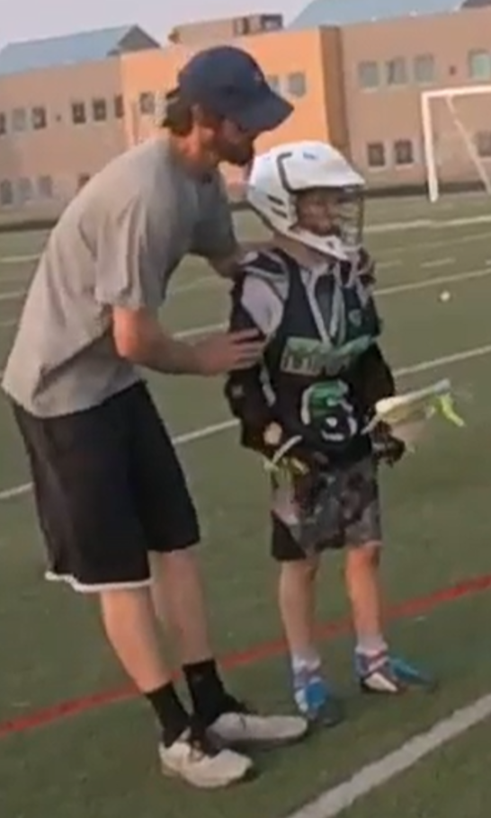 Coach Taylor directing a young camper at the Summer Showdown Lacrosse Camp 2021